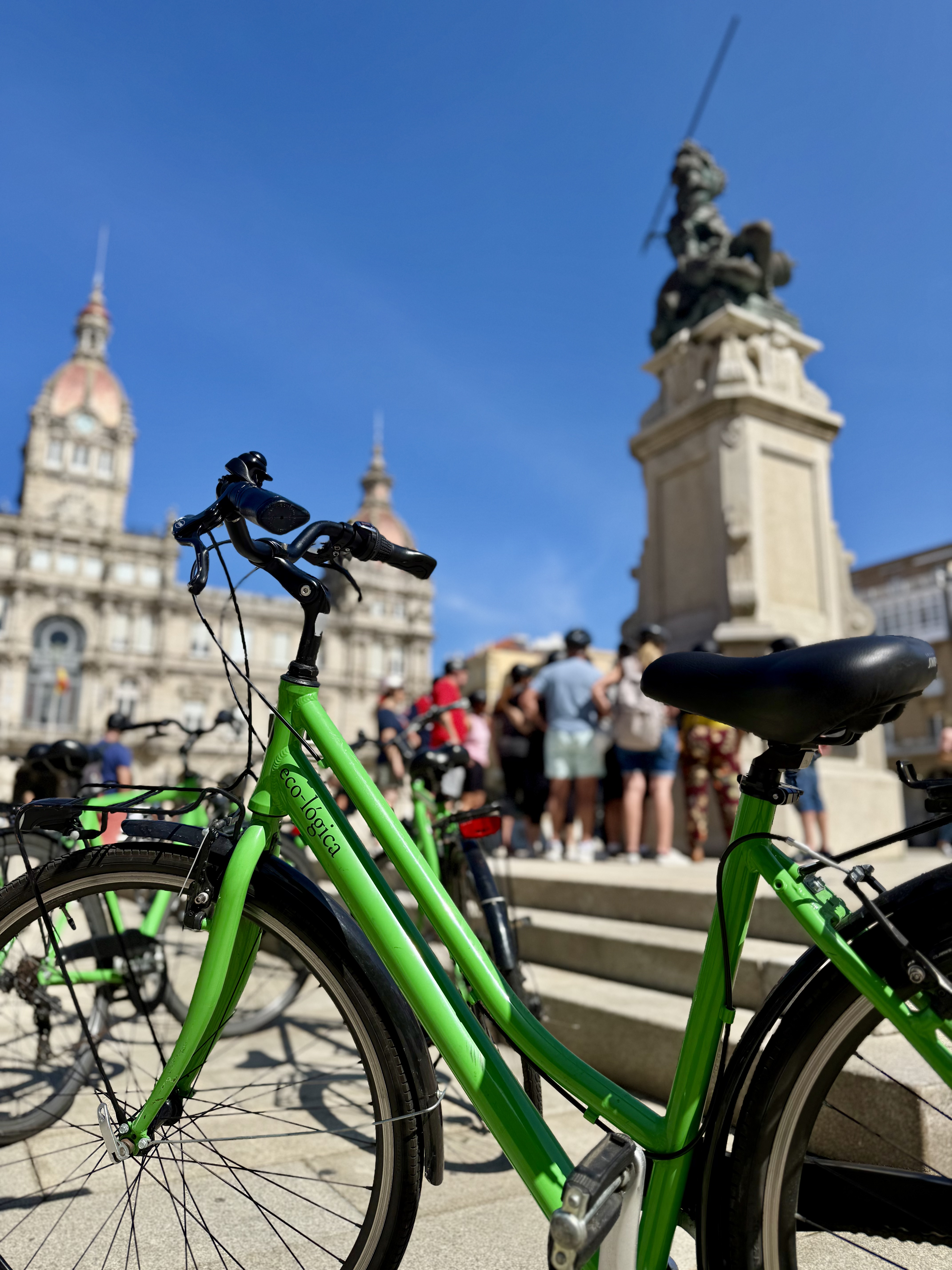 Bicicleta convencional verde de eco-lógica en primer plano en la plaza de María Pita
